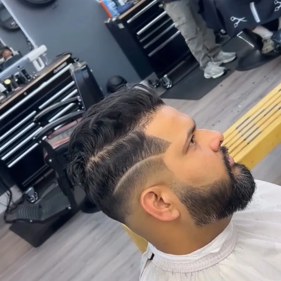 Skin fade with a hair design and full beard